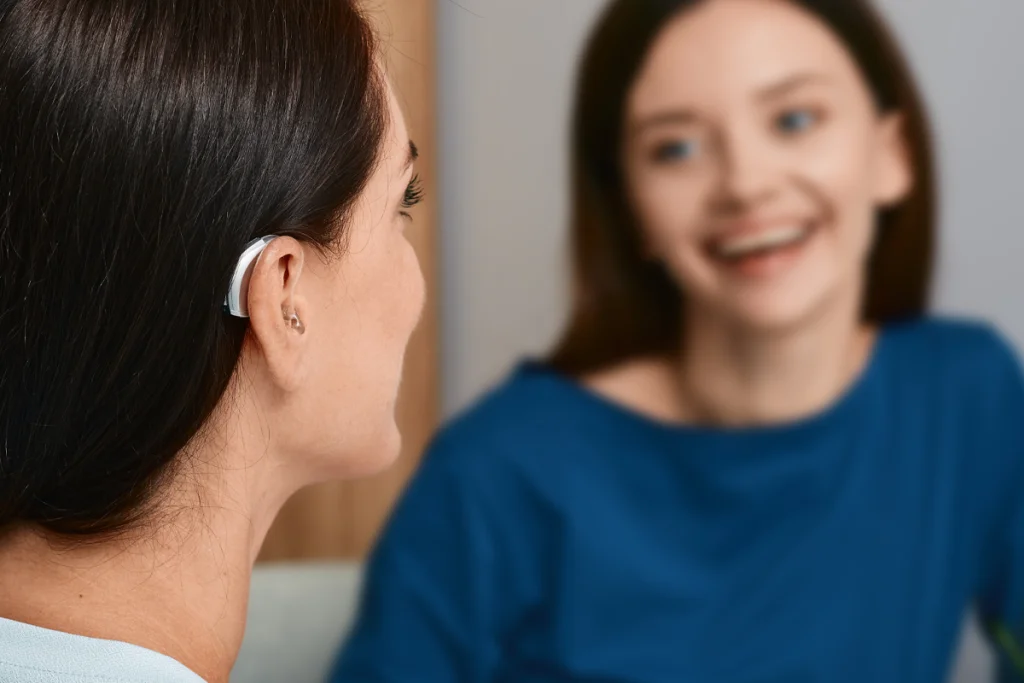 A woman with hearing aids talks with a friend