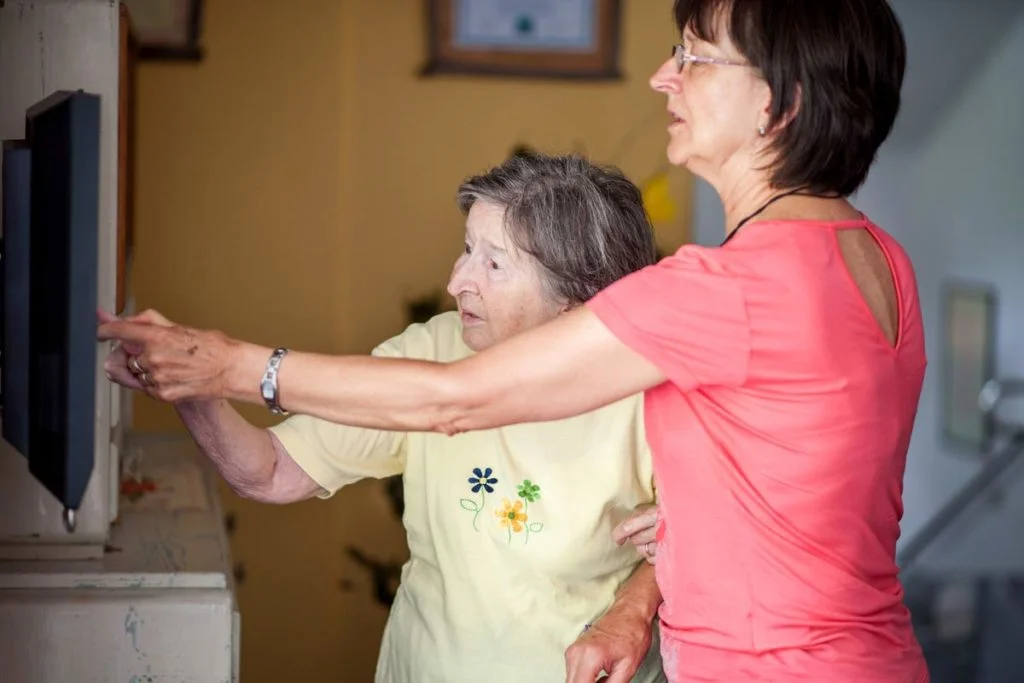 woman helping mother learn smarthome system