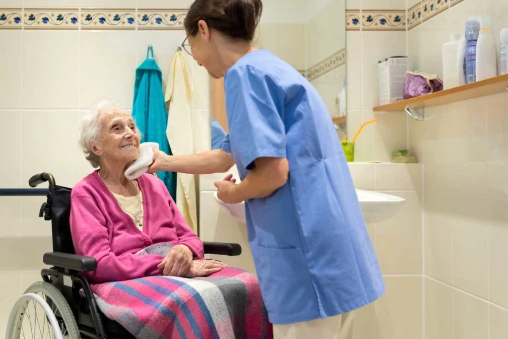 Elderly accompanied by a caregiver in a bathroom