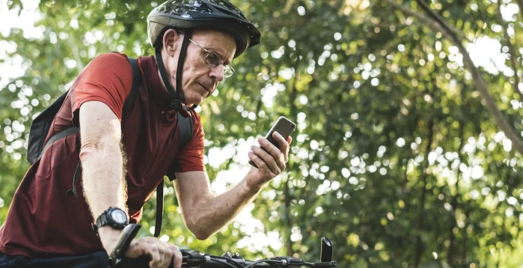 senior cyclist using the gps on his phone