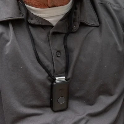 Man in grey polo wears a medical alert necklace