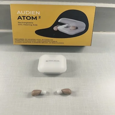 The Audien Atom 2 with its charging case and outer packaging.