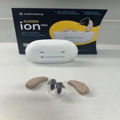 The Audien Ion Pro hearing aids next to their charging case and outer packaging.