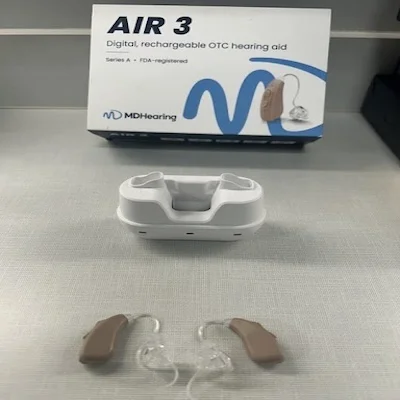 MDHearing AIR 3 hearing aid unboxed on a table with its packaging.