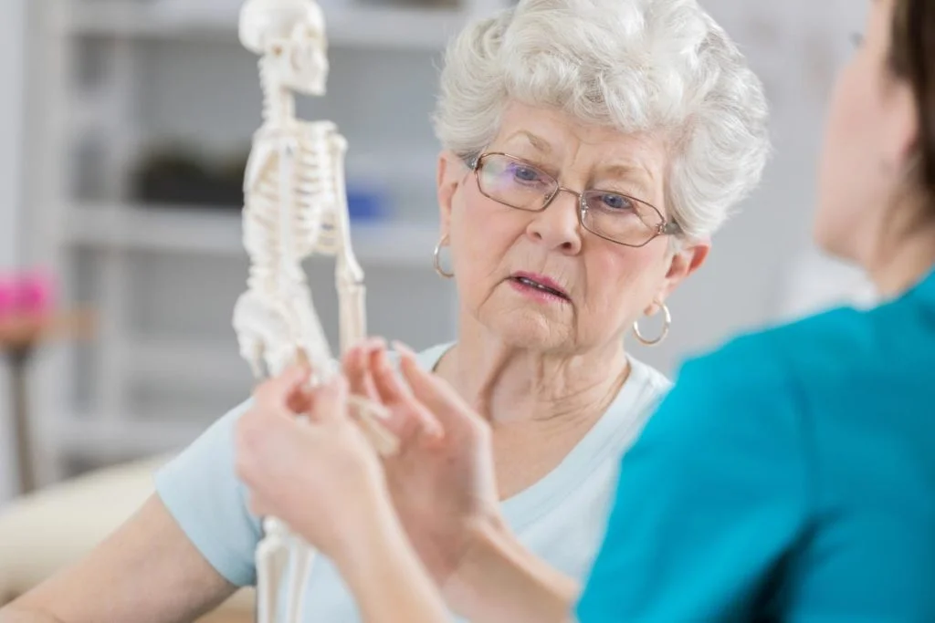 senior with nurse examining